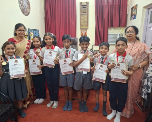 All smiles as the International Talent Olympiad of Primary Section pose with their medals and report cards with Principal Madam and Senior HM madam
